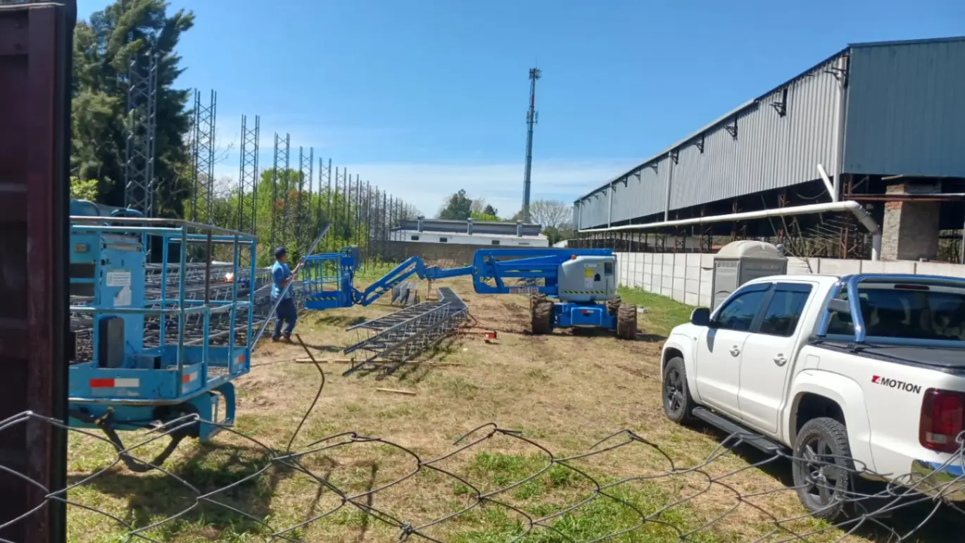 Plataforma elevadora Genie 4x4 en obra rural con camioneta de servicio en Uruguay