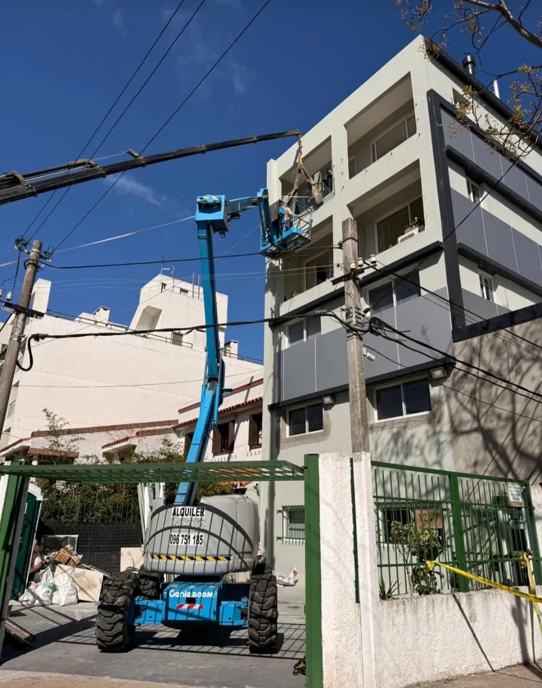 Plataforma elevadora Genie trabajando en fachada de edificio urbano en Uruguay