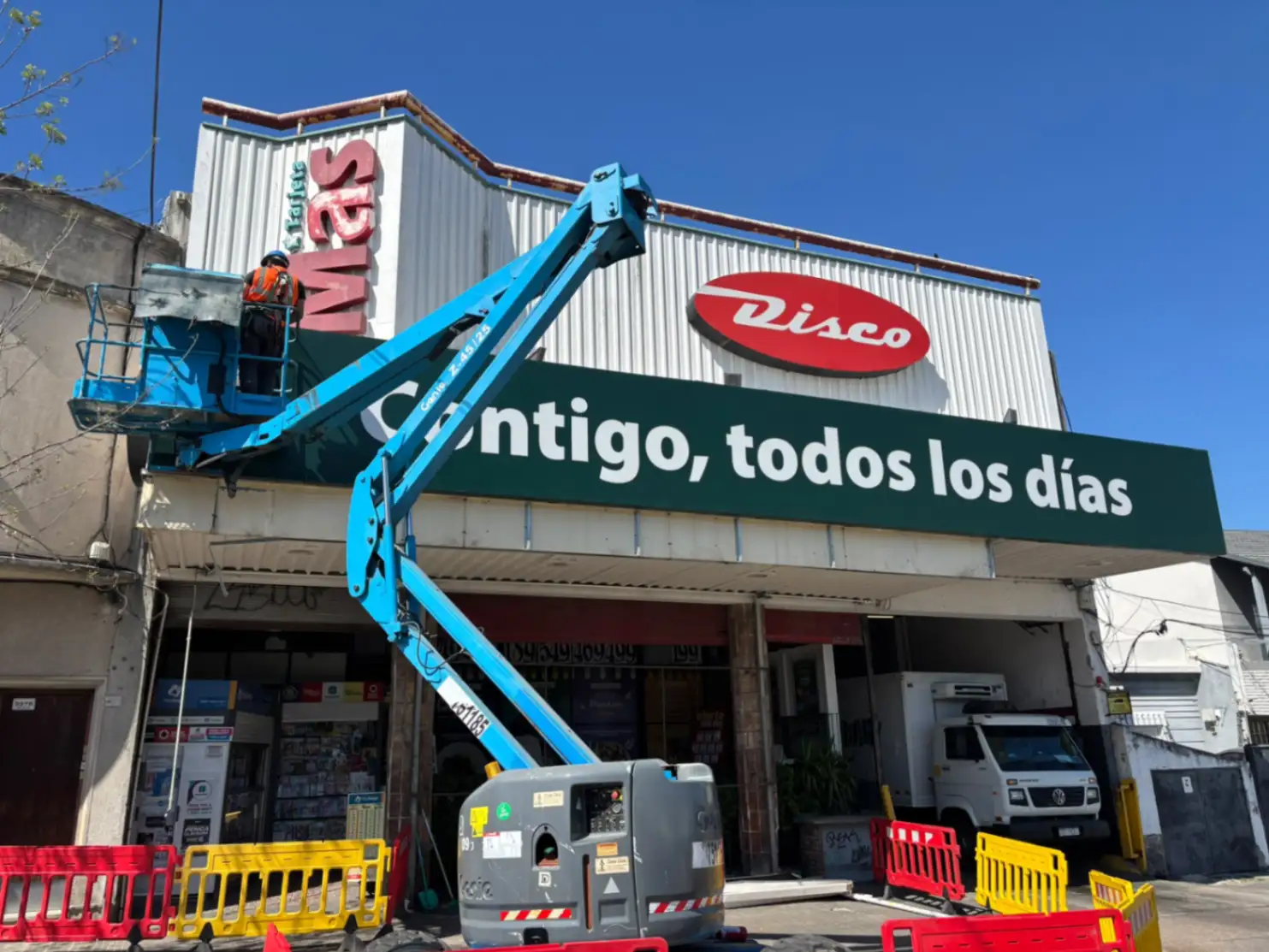 Plataforma elevadora Genie trabajando en cartelería comercial en Uruguay