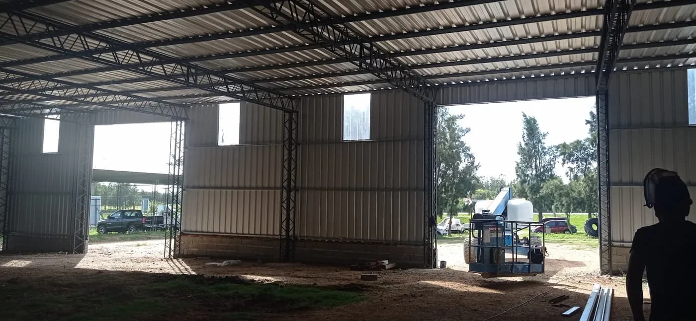 Plataforma elevadora trabajando en interior de galpón en construcción en Uruguay
