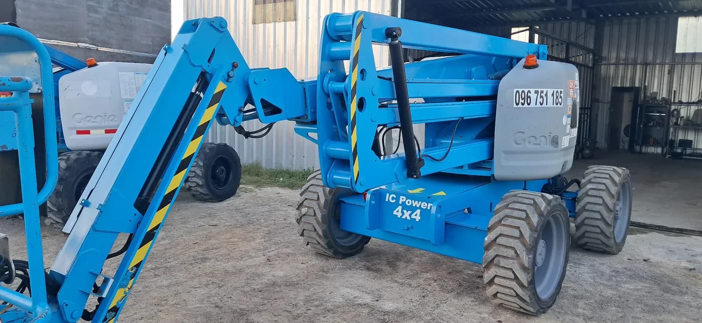 Plataforma elevadora Genie 4x4 junto a camión de MF Construcciones en Uruguay