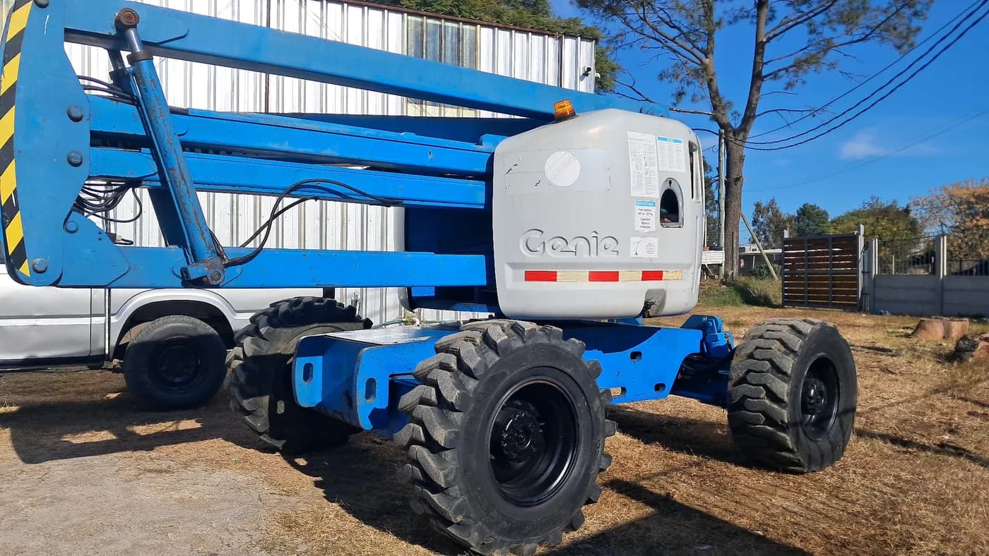 Plataforma elevadora Genie estacionada junto a galpón en Uruguay